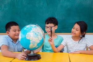 a group of Asian students studying the world globe